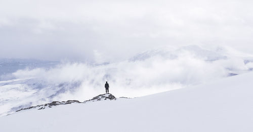 Person skiing on snowcapped mountains against sky