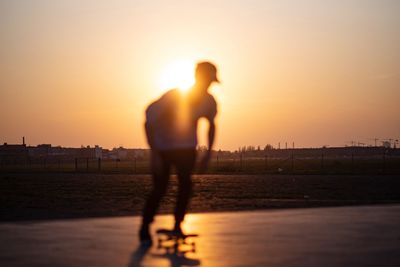 Silhouette man standing against sky during sunset