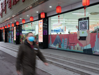 Blurred motion of woman walking on illuminated city