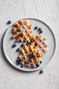 Breakfast with waffles with blueberries and syrup on a plates