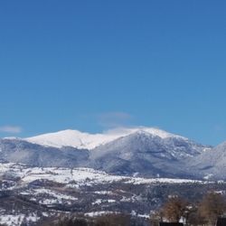 Scenic view of snowcapped mountains against blue sky