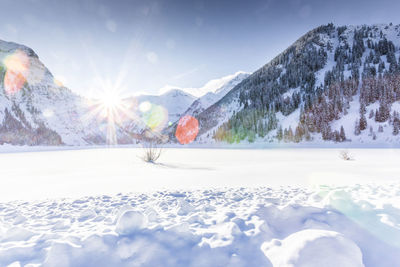 Scenic view of snow covered land and mountains against sky