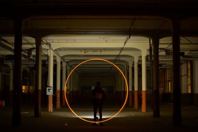 Silhouette man standing by circle shape on railroad station