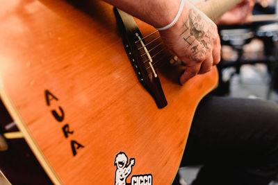 Close-up of hand holding text on wood