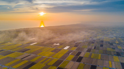 Aerial view of field against sky during sunset