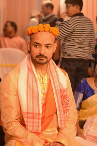 Young bridegroom in traditional clothes sitting wedding ceremony