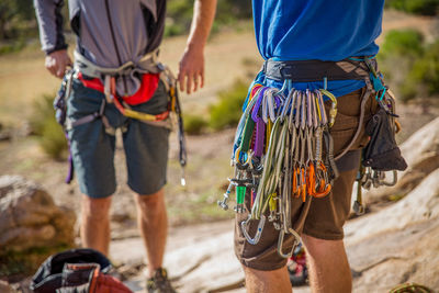 Midsection of man with umbrella standing on rope