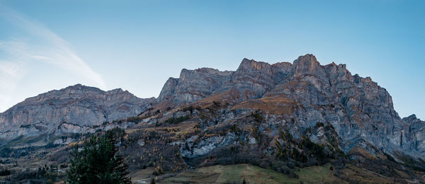 Low angle view of rocky mountains against sky