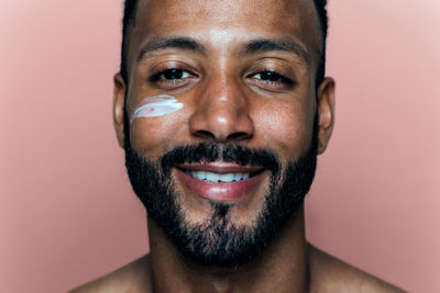 Close-up portrait of young man against white background