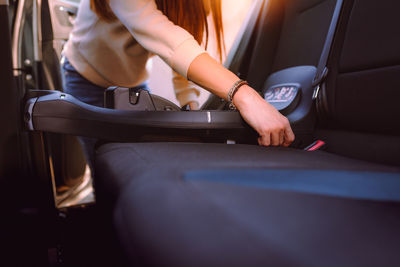 Midsection of woman sitting in car