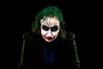 Portrait of woman wearing mask against black background