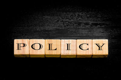 Directly above shot of information sign on table against black background