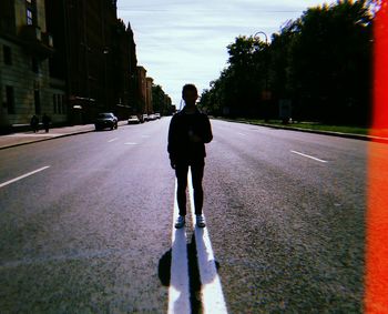 Rear view of man walking on road