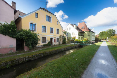 Houses by street amidst buildings against sky
