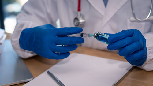 Midsection of man holding hands on table