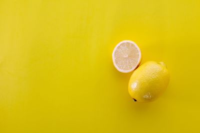 Close-up of lemon against yellow background
