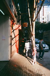 Rear view of people walking on street amidst buildings