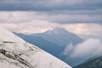 Scenic view of snowcapped mountains against cloudy sky