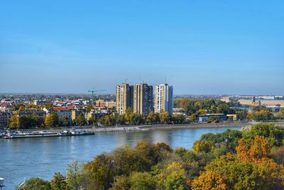River by buildings against sky in city