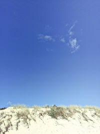 View of snow covered landscape against blue sky