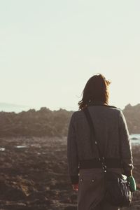 Rear view of woman standing against clear sky