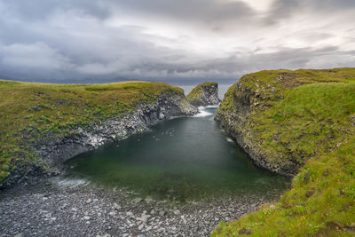 Scenic view of river amidst rocks against sky
