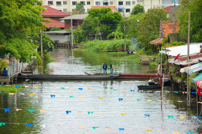 Boats in canal by buildings in city