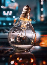 Close-up of illuminated light bulb on table