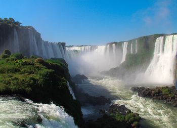 Scenic view of waterfall against sky