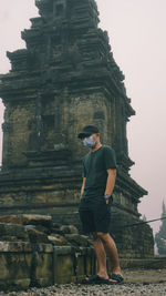 Full length of man standing outside temple against building