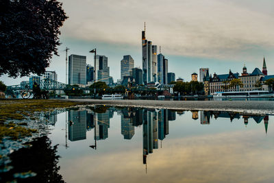 Reflection of buildings in river against sky