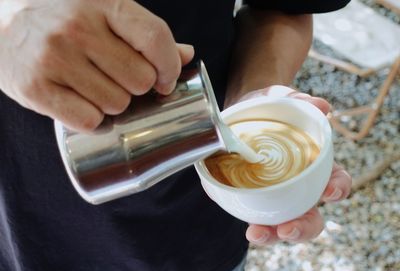Midsection of man holding coffee