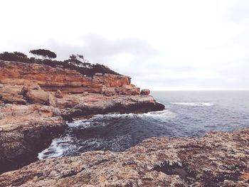 Scenic view of rocks on beach against sky