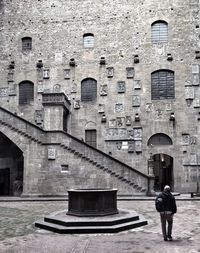 Rear view of man against historic building in city