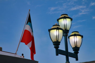 Low angle view of street light against blue sky