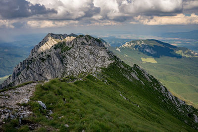 Scenic view of land and mountains against sky