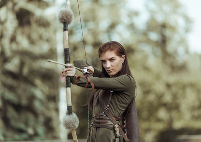 Female archer standing on field