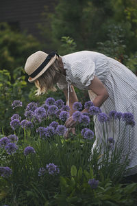 Rear view of woman sitting amidst flowers