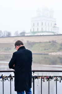 Rear view of man standing on railing