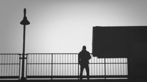 Rear view of silhouette man standing against sky