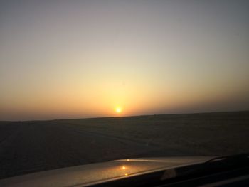 Scenic view of land against clear sky during sunset