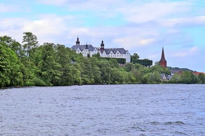 Scenic view of river by building against sky