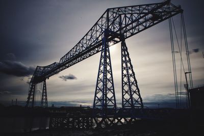 Low angle view of crane against sky at sunset