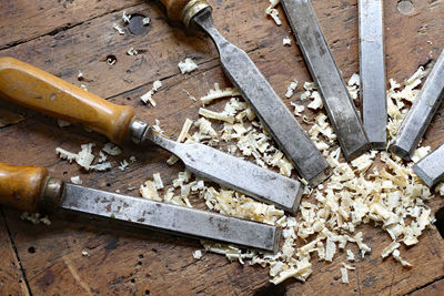 Close-up of chisel and wood shavings on table