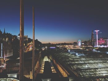 High angle view of illuminated bridge and buildings against sky at night