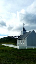 Scenic view of grassy field against cloudy sky