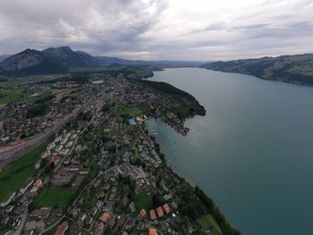 High angle view of city by sea against sky