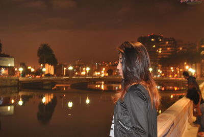 Reflection of illuminated people in water at night