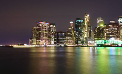 Illuminated buildings in city against sky at night