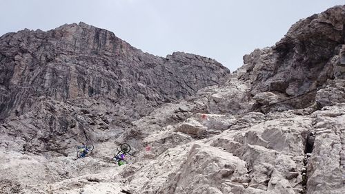 Low angle view of bikers on majestic rocky mountain